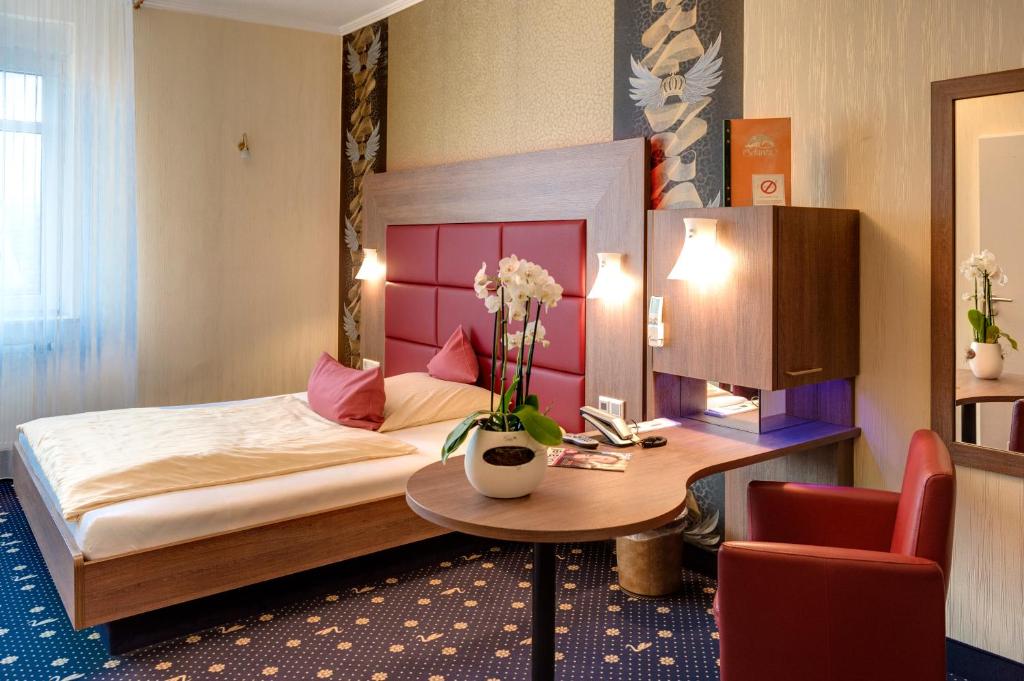 Ambient-Hotel zum Schwan, Gelsenkirchen-Buer Foto Einzelzimmer mit Bett, Schreibtisch und Sessel